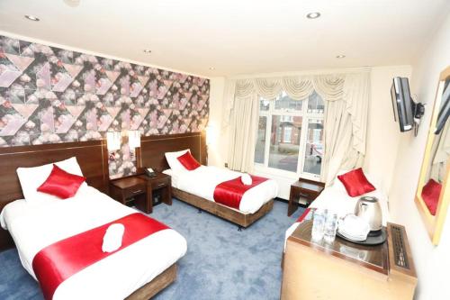 a hotel room with two beds and a window at Acorn Lodge Hotel Gatwick & Parking in Horley