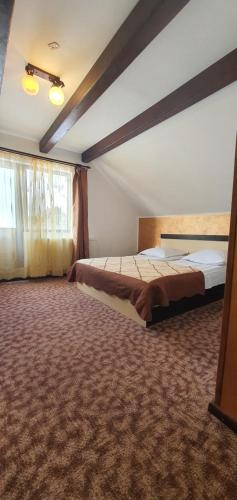 a bedroom with two beds and a large window at Vila Dascalita in Moieciu de Sus
