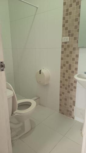 a white bathroom with a toilet and a sink at Hotel Montecarlo by Croma in Santiago