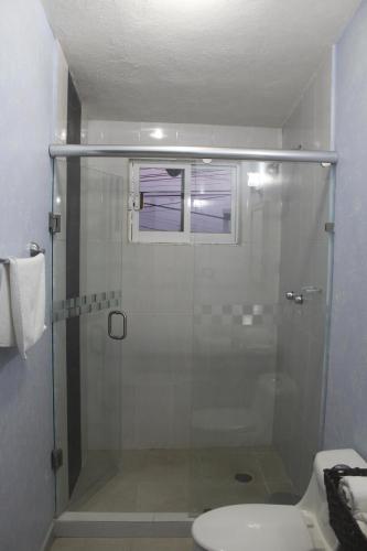 a bathroom with a glass shower with a toilet at Villas Tecuanapan in Xalapa