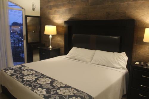 a bedroom with a large bed with a black headboard at Villas Tecuanapan in Xalapa