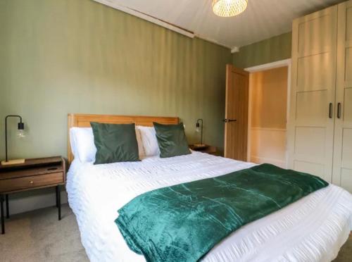 a bedroom with a large green and white bed at High Tide in Whitstable
