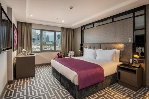 a hotel room with a bed and a large window at Courthouse Hotel Shoreditch in London