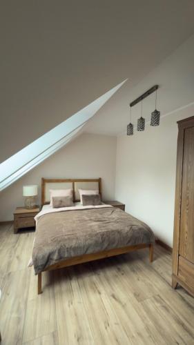 a bedroom with a large bed in a attic at Apartament Cisza Leśna in Gołubie