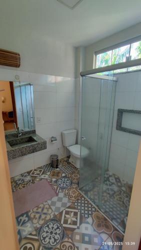 a bathroom with a glass shower and a toilet at Casa das Flores Bistrô e Pousada in Taquarussu Tocantins