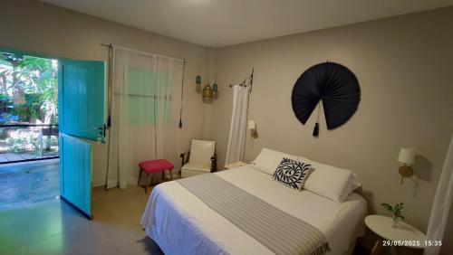a bedroom with a bed and an umbrella on the wall at Casa das Flores Bistrô e Pousada in Taquarussu Tocantins