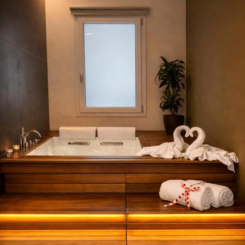 a bathroom with a tub with swan towels on a counter at L'Incanto Suite - B&B Surano LE in Surano
