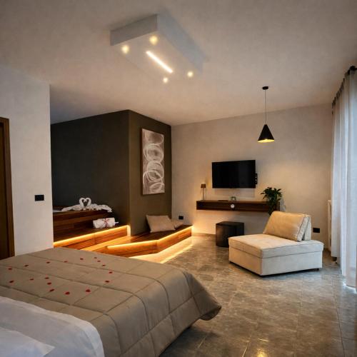 a bedroom with a bed and a couch and a tv at L'Incanto Suite - B&B Surano LE in Surano