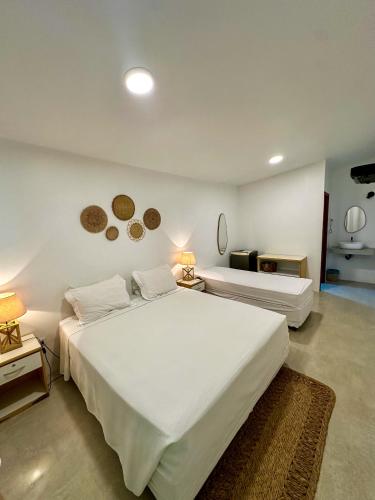 a bedroom with two white beds and two lamps at Pousada Brisa Mar in Fernando de Noronha