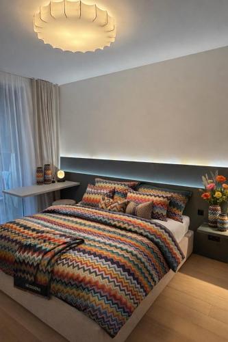 a bedroom with a large bed with a colorful blanket at Sky Park by MISSONI in Nivy