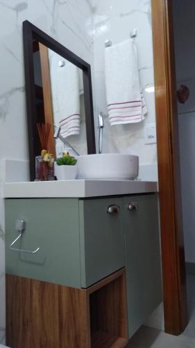 a bathroom with a sink and a mirror at Casa em local tranquilo - Bairro Recanto dos Pássaros in Cuiabá