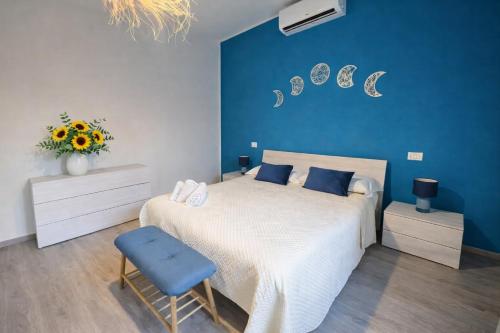 a bedroom with a bed and a blue wall at Luna D'Argento Apartment in Porto Ercole