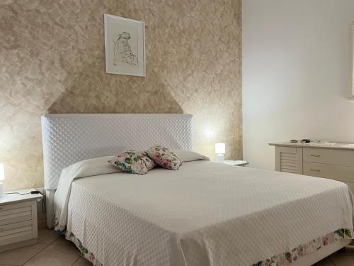 a bedroom with a white bed with two pillows at Sciara casa vacanze in Viagrande