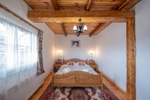 a bedroom with a bed and a large window at Casa Vlădușca in Peştera