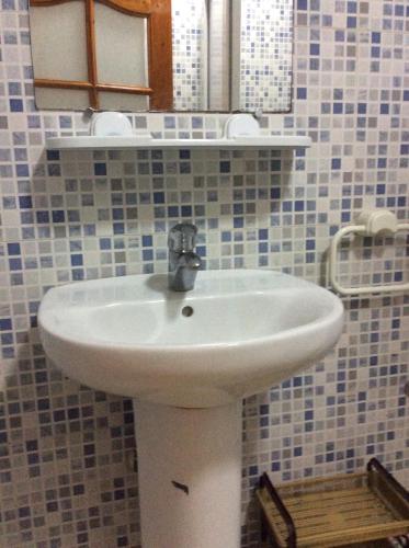 a bathroom with a white sink and a mirror at Résidence La Galiote in Essaouira
