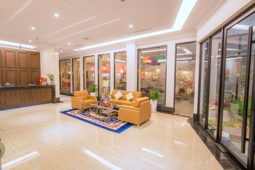 a lobby with couches and tables in a building at Paradise Hotel in Phnom Penh