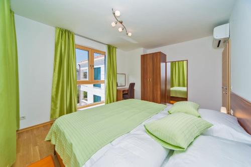 a bedroom with a bed with green sheets and a window at Villa Slano in Slano