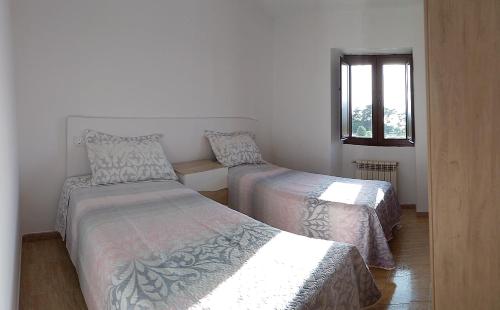 a bedroom with two beds and a window at Eira de Mantoño in Mantoño