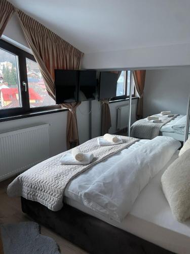 a bedroom with a bed with towels on it at Marova Luxury Loft Caraiman View in Buşteni