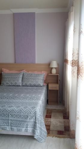 a bedroom with a bed with a blue comforter at Lindo Flat no Centro de Caxambu in Caxambu