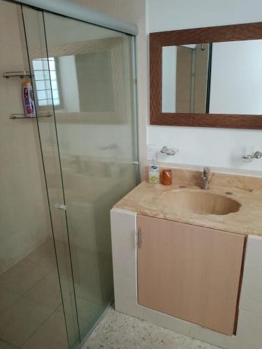 a bathroom with a sink and a glass shower at Hotel Mi Casa Mata II in Morelia