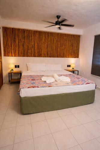 a bedroom with a large bed with two night stands at Hotel VSI in Playa del Carmen