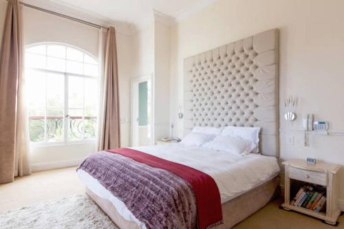 a bedroom with a large bed with a large window at 15A on Hove in Cape Town