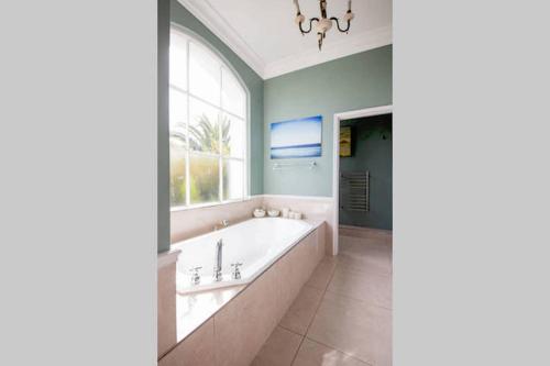 a bathroom with a bath tub and a window at 15A on Hove in Cape Town