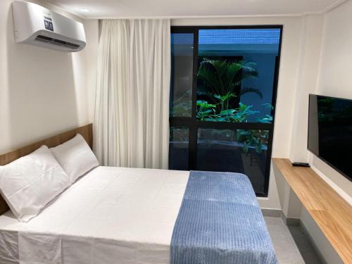 a bedroom with a bed and a fish tank in a window at Flat Hit Cabo Branco in João Pessoa