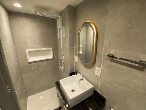 a bathroom with a sink and a mirror at Flat Hit Cabo Branco in João Pessoa