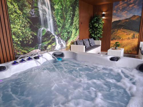 a jacuzzi tub in a room with a waterfall at Agroturystyka Gazdówka in Zakliczyn
