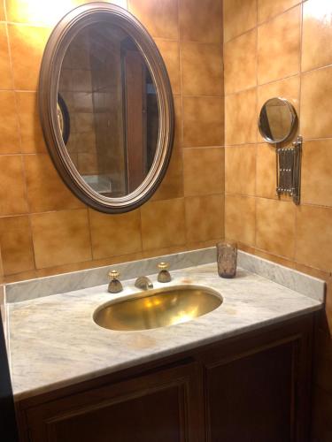 a bathroom sink with a mirror and a counter at Chacra Los Cipreses - Casa completa con gran parque arbolado, 6 personas, entorno tranquilo in Cinco Saltos