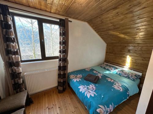 a small bedroom with a bed in a wooden house at Casa de vacanta Cabana Toto in Sebeşu de Jos