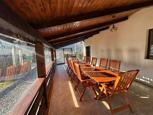 a row of wooden tables and chairs on a patio at Casa de vacanta Cabana Toto in Sebeşu de Jos