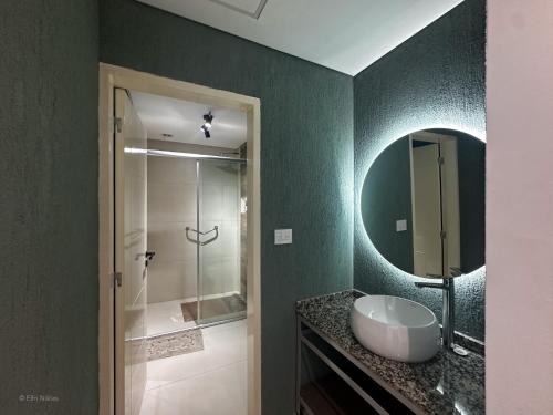 a bathroom with a sink and a shower with a mirror at Apart Lunge in Córdoba