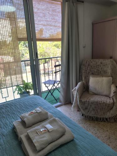 a bedroom with a bed and a chair and a window at Departamentos Le & Lo in Cipolletti