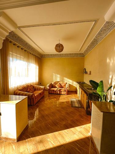 a living room with two couches and a table at Catamaran Surf House in Agadir nʼ Aït Sa