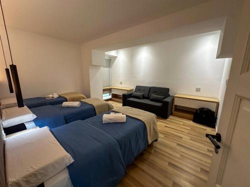 a hotel room with three beds and a chair at Apart Lunge in Córdoba