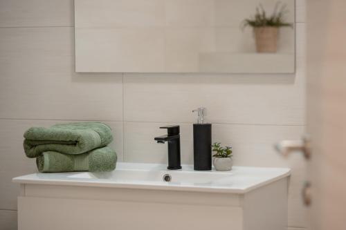 a bathroom sink with a green towel and a faucet at House Hana 2415 in Vodnjan
