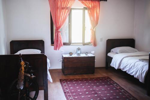 a bedroom with two beds and a window and a rug at Kuća za odmor San in Lonja