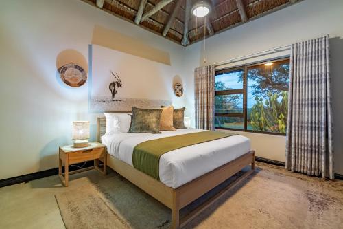 a bedroom with a large bed and a window at Phelwana Game Lodge in Hoedspruit