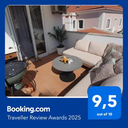 a living room with a couch and a table on a balcony at Casa Portao da Cidade in Silves