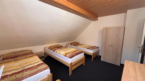 a room with two beds and a cabinet at Chalupa U lesa in Karlova Studánka