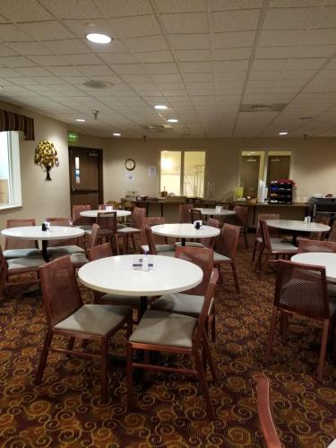 a dining room with tables and chairs in a restaurant at Crystal Inn Hotel & Suites - Great Falls in Great Falls