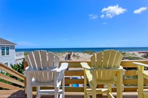two chairs sitting on a deck overlooking the beach at 7081 - Southern Breeze in Nags Head