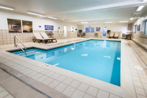 a large swimming pool with blue water in a building at Crystal Inn Hotel & Suites - Great Falls in Great Falls