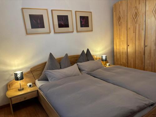 a bed in a bedroom with two lamps on a table at Ferienwohnung Wohlesser in Annaberg im Lammertal