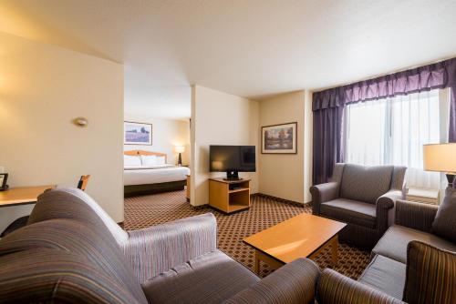 a hotel room with a couch and a bed at Crystal Inn Hotel & Suites - Great Falls in Great Falls