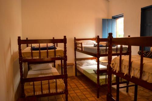 a room with three bunk beds and a window at Casarão Duque do Mel in João Pessoa