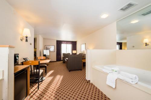 a hotel room with a tub and a living room at Crystal Inn Hotel & Suites - Great Falls in Great Falls